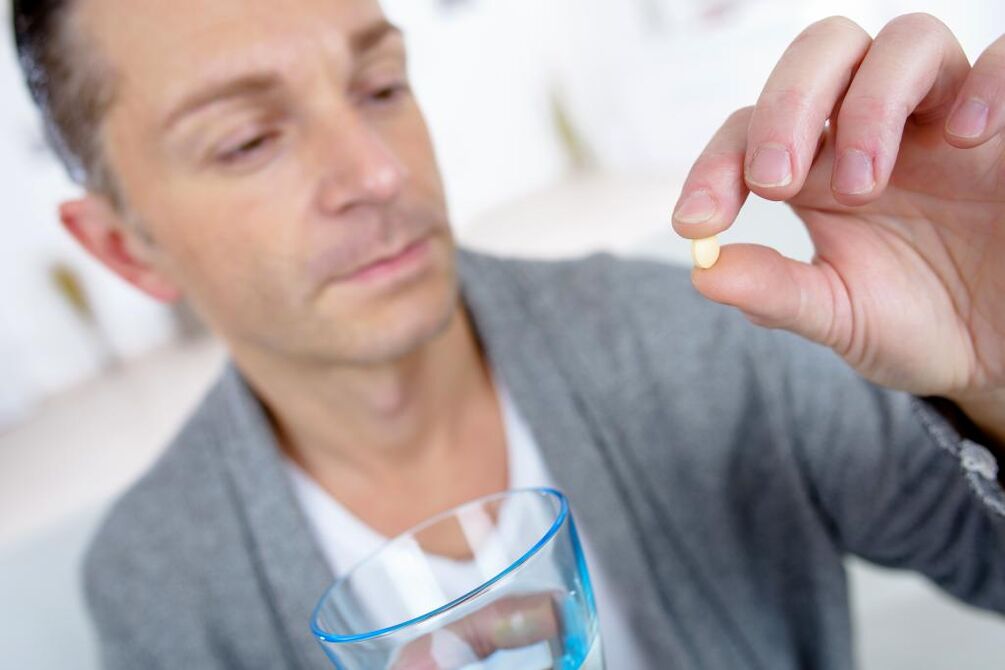 un hombre toma una pastilla para aumentar la potencia